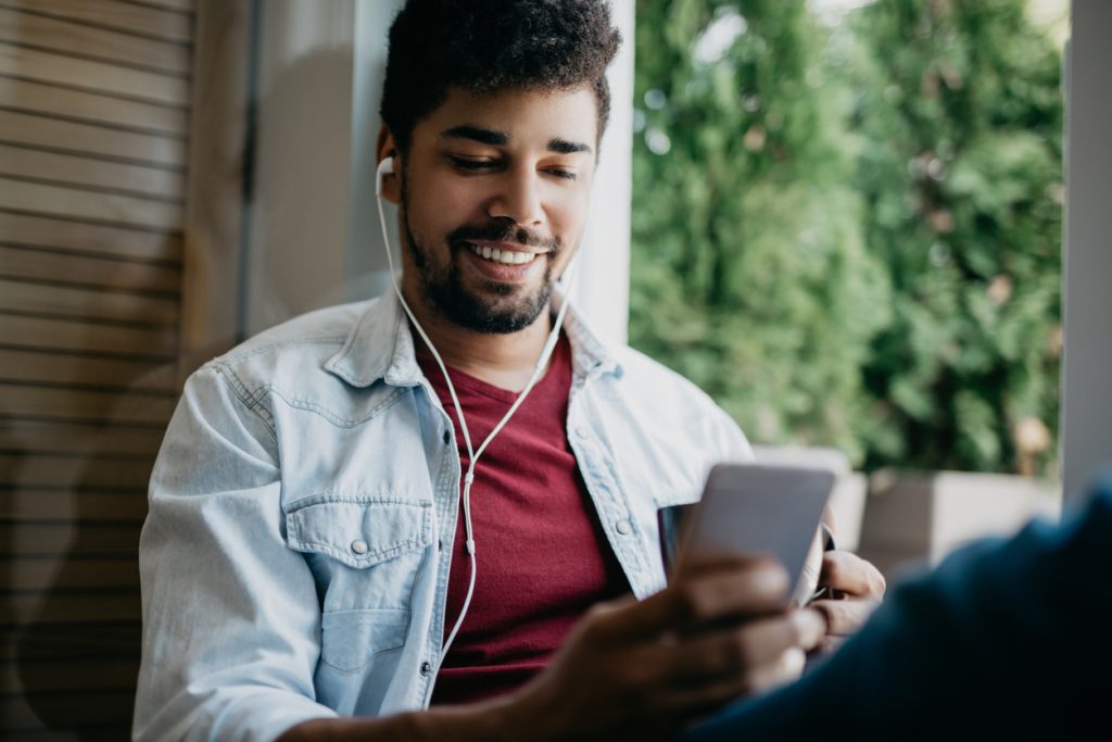 Person wearing headphones listening to podcast on mobile device