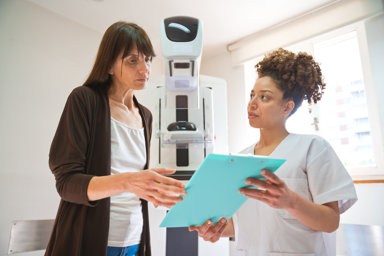 Young nurse talking with female patient